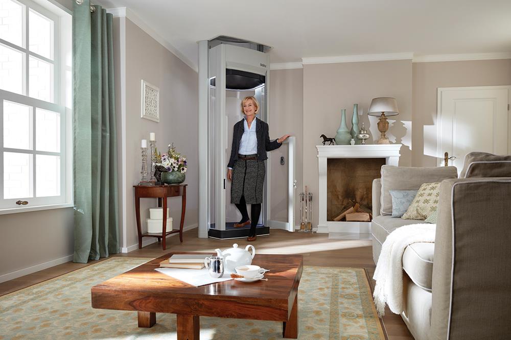 A lady coming out of a homelift in a living room